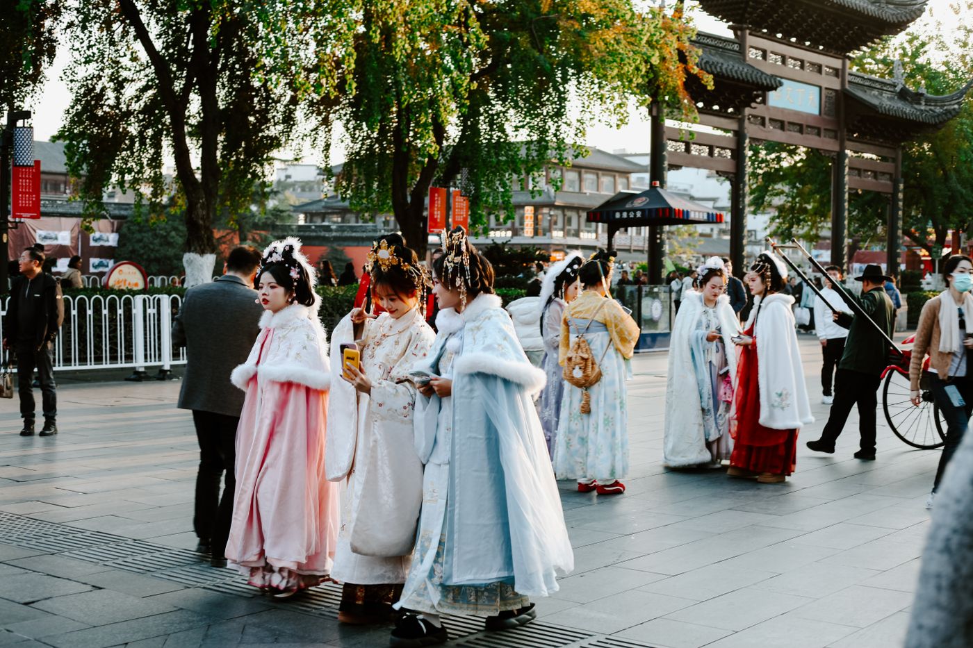 People in traditional Chinese hanfu strolling through a city street